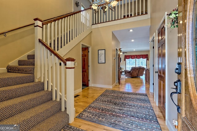 1068 Coleman River Rd, Clayton, GA 30525 - entrance foyer featuring wood finished floors, stairway, a chandelier, baseboards, and a high ceiling