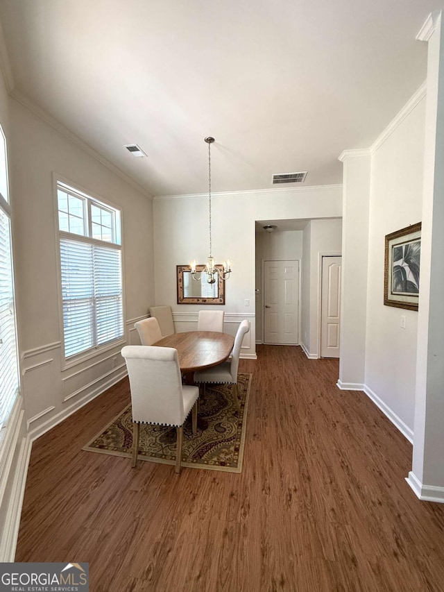 dining space featuring visible vents, dark wood-type flooring, and ornamental molding