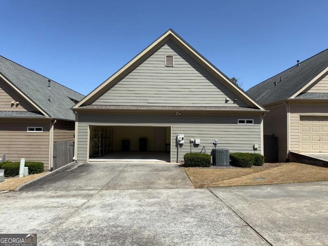 garage with concrete driveway, a gate, and central AC unit