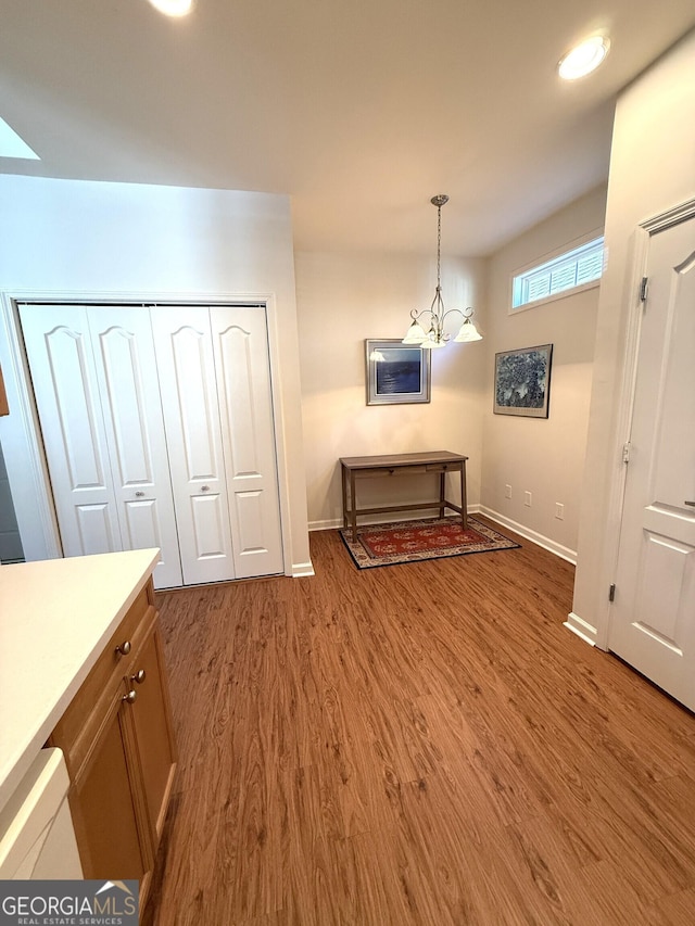 dining area with a notable chandelier, baseboards, and wood finished floors