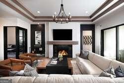 home theater with a notable chandelier, a lit fireplace, and ornamental molding