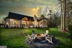 back of property at dusk featuring an outdoor fire pit and a yard