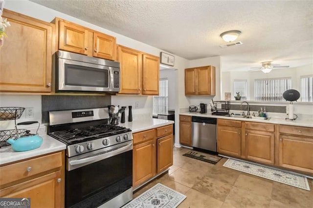 kitchen with a sink, light countertops, a healthy amount of sunlight, and stainless steel appliances