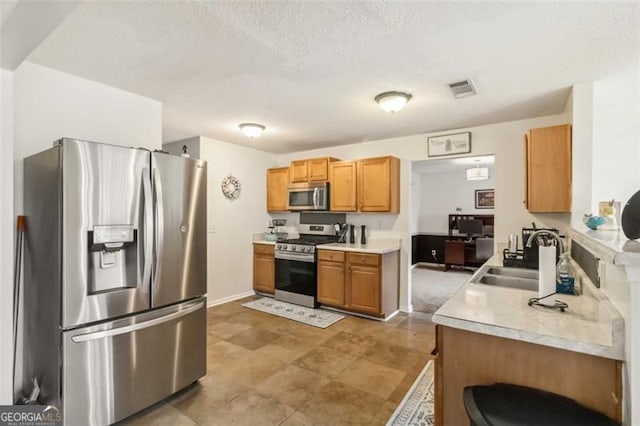 kitchen featuring light countertops, visible vents, appliances with stainless steel finishes, and a sink