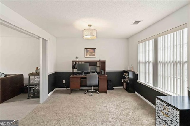 home office with visible vents, a textured ceiling, baseboards, and carpet floors