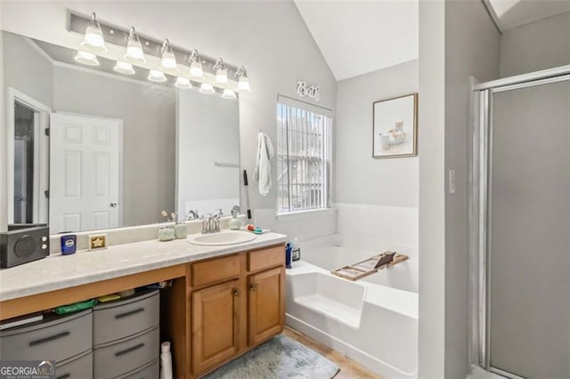 full bathroom with lofted ceiling, a garden tub, a stall shower, and vanity