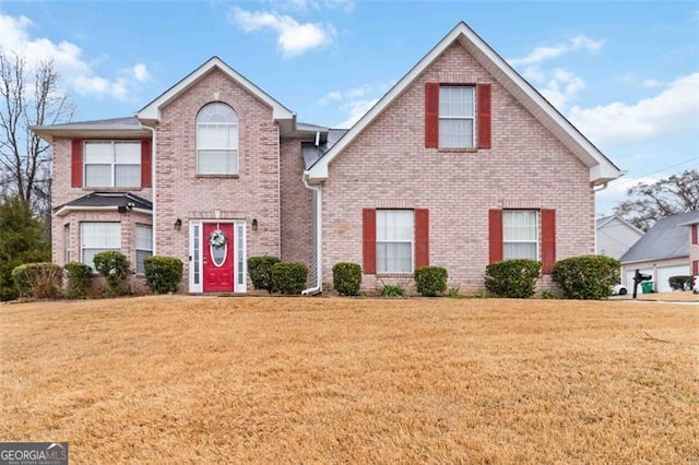 traditional-style home with a front yard and brick siding