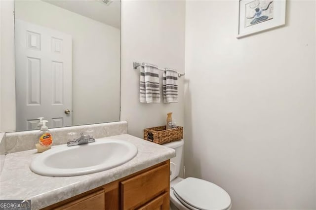 bathroom featuring toilet and vanity