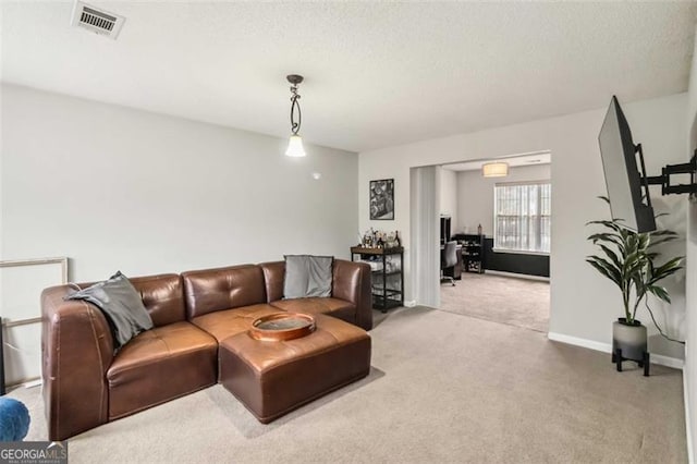 carpeted living area featuring visible vents, baseboards, and a textured ceiling