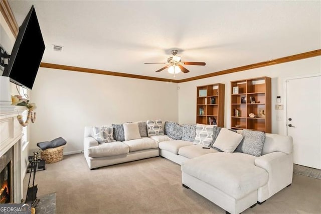 carpeted living room featuring visible vents, a lit fireplace, ornamental molding, and a ceiling fan