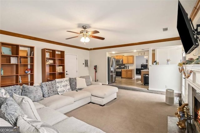 living area featuring visible vents, a fireplace with flush hearth, light carpet, a ceiling fan, and crown molding