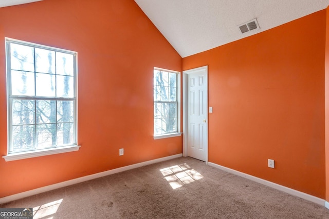 empty room featuring a wealth of natural light, carpet, baseboards, and visible vents