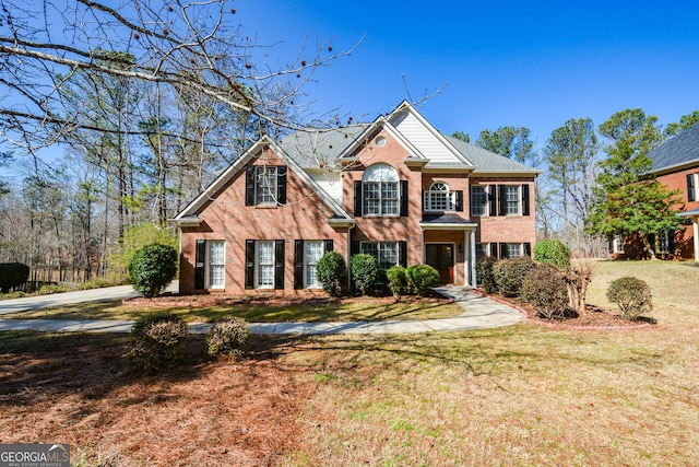 view of front of property with a front lawn and brick siding