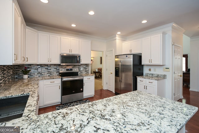 kitchen with decorative backsplash, white cabinetry, stainless steel appliances, and crown molding