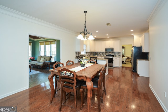 dining area featuring visible vents, dark wood-type flooring, baseboards, ornamental molding, and an inviting chandelier