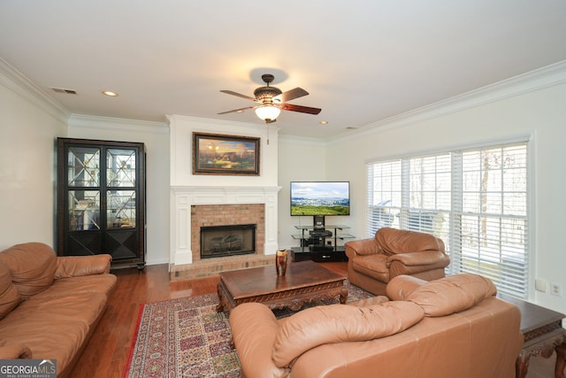 living area with visible vents, crown molding, a ceiling fan, and wood finished floors