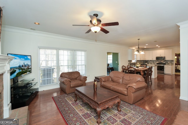 living area featuring a healthy amount of sunlight, crown molding, and ceiling fan with notable chandelier