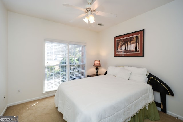 bedroom with ceiling fan, light colored carpet, visible vents, and baseboards