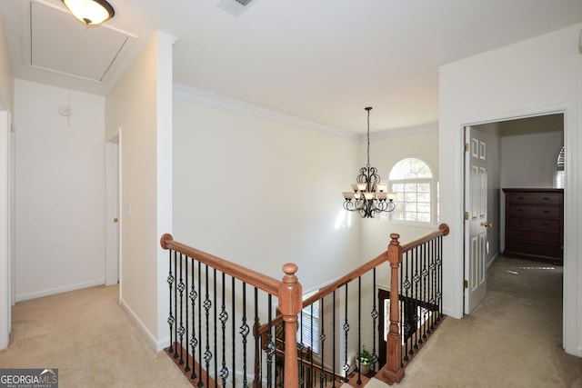 hallway with crown molding, baseboards, attic access, an upstairs landing, and carpet flooring