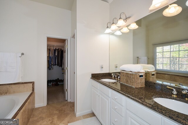 full bath with a spacious closet, tile patterned floors, double vanity, and a sink