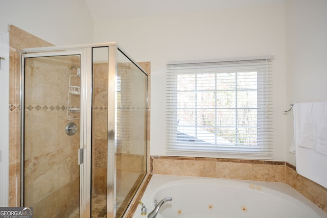 bathroom featuring a tub with jets and a stall shower