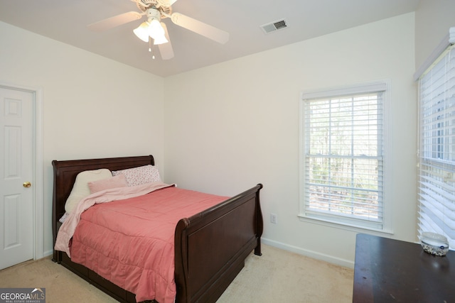 bedroom with multiple windows, baseboards, visible vents, and light carpet