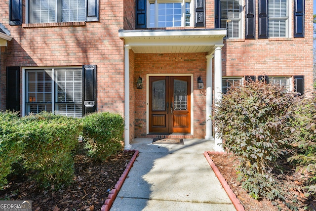 entrance to property featuring french doors and brick siding
