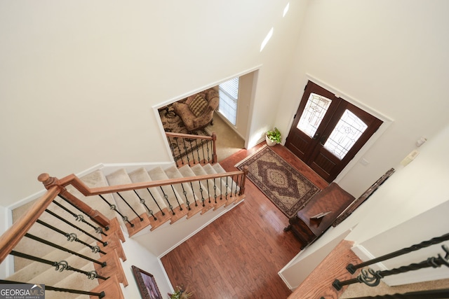 entryway with stairway, a towering ceiling, and wood finished floors