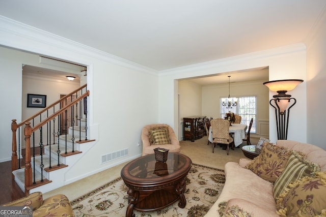 carpeted living room featuring visible vents, crown molding, baseboards, stairway, and a notable chandelier