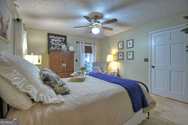 carpeted bedroom with a textured ceiling and a ceiling fan