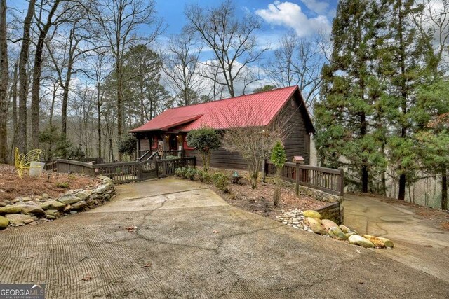 exterior space with metal roof and concrete driveway