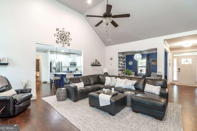 living room featuring a wealth of natural light, ceiling fan with notable chandelier, high vaulted ceiling, and dark wood-style flooring