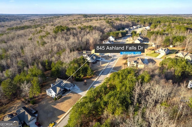 birds eye view of property featuring a wooded view