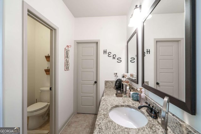 bathroom with baseboards, toilet, vanity, and tile patterned flooring