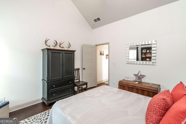 bedroom with baseboards, lofted ceiling, dark wood-type flooring, and visible vents