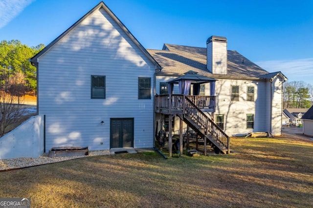 back of house featuring a gazebo, a chimney, stairs, and a yard