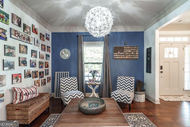 living area featuring crown molding, a notable chandelier, wood finished floors, and plenty of natural light