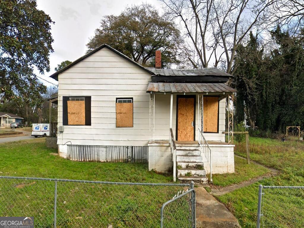 528 W College St, Americus, GA 31709 - bungalow-style home featuring a chimney, a front yard, and fence