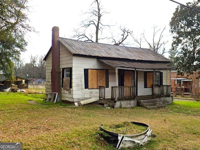 528 W College St, Americus, GA 31709 - rear view of property featuring covered porch, a chimney, and a yard
