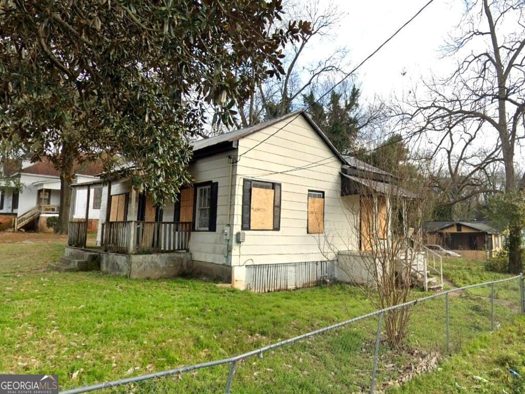 528 W College St, Americus, GA 31709 - view of side of home with crawl space, a yard, covered porch, and fence
