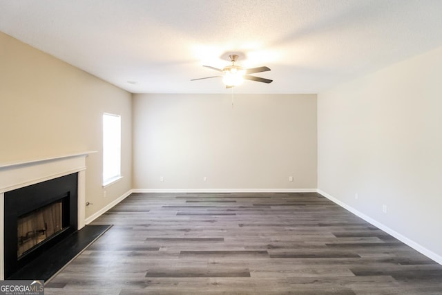5345 Bridle Point Pkwy, Snellville, GA 30039 - unfurnished living room featuring dark wood-style floors, a fireplace with raised hearth, baseboards, and ceiling fan