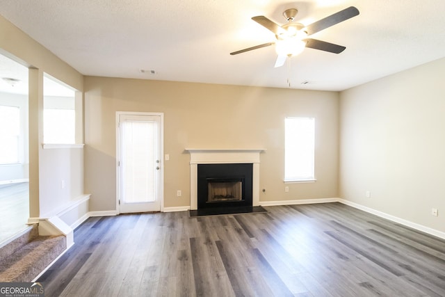 5345 Bridle Point Pkwy, Snellville, GA 30039 - unfurnished living room with visible vents, dark wood-type flooring, a ceiling fan, a fireplace, and baseboards