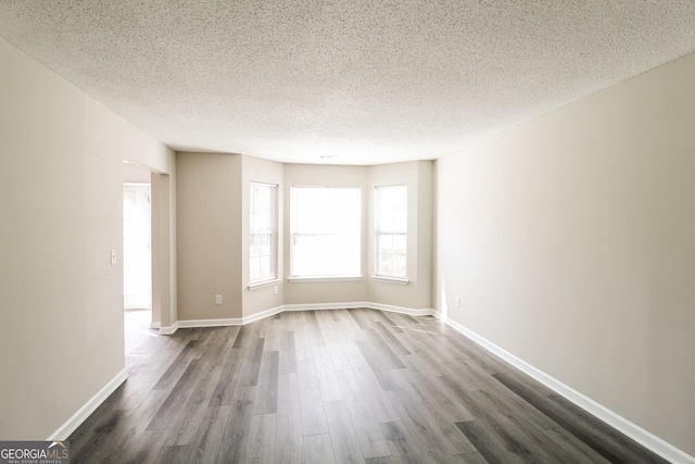 5345 Bridle Point Pkwy, Snellville, GA 30039 - empty room featuring dark wood finished floors, a textured ceiling, and baseboards