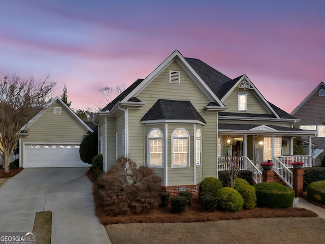 view of front facade featuring an outdoor structure, covered porch, concrete driveway, and a shingled roof