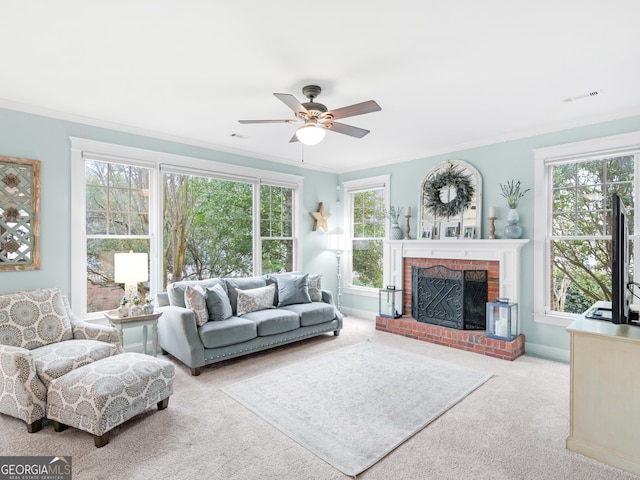 living area with visible vents, a fireplace, ornamental molding, ceiling fan, and carpet flooring