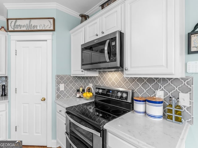 kitchen featuring tasteful backsplash, appliances with stainless steel finishes, white cabinetry, and crown molding