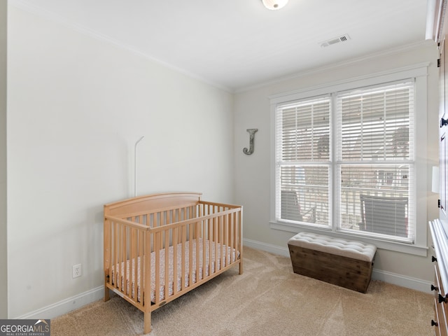 carpeted bedroom with visible vents, a nursery area, baseboards, and ornamental molding