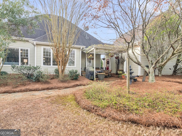 view of front of home featuring a pergola and roof with shingles