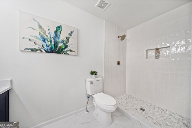 bathroom with visible vents, baseboards, toilet, tiled shower, and marble finish floor