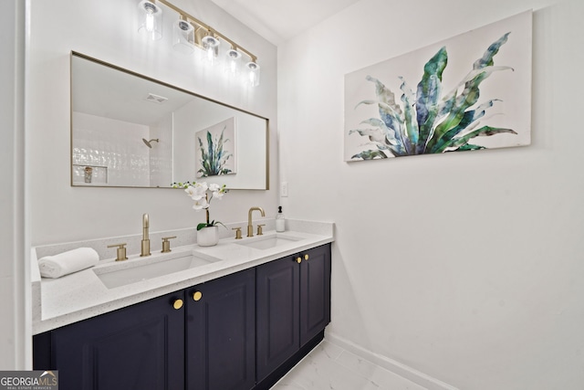 bathroom with a sink, baseboards, marble finish floor, and double vanity